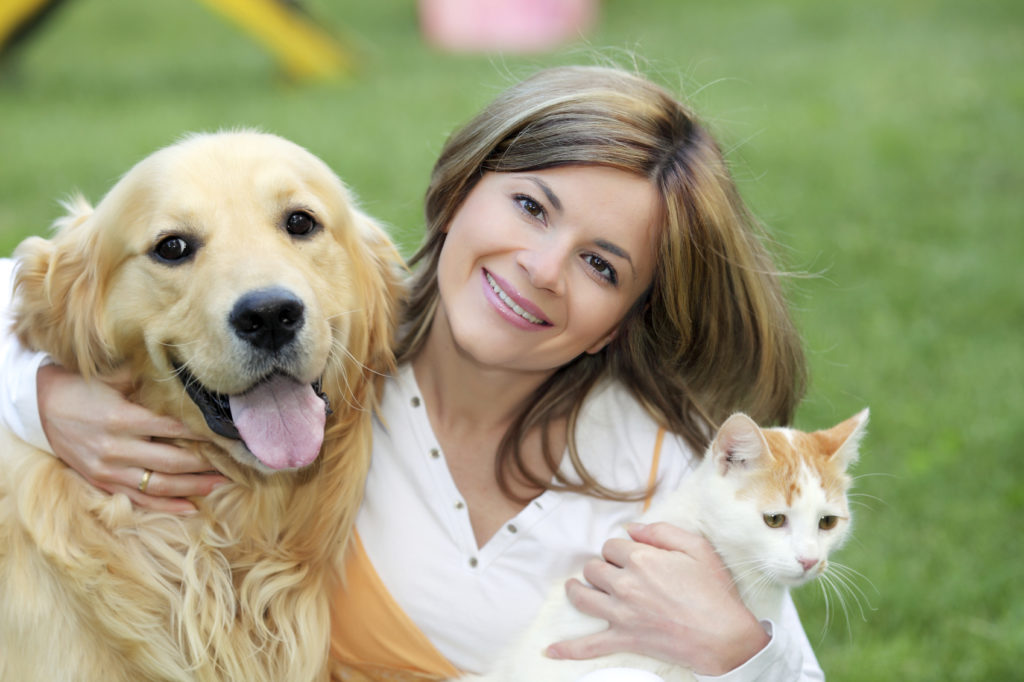 Portrait of a young woman with dog and cat.